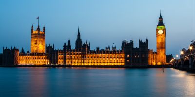 Photo of Houses of Parliament lit up against blue sky
